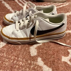 Nike White Low-Top Sneakers with Black Swoosh and Gold Trim